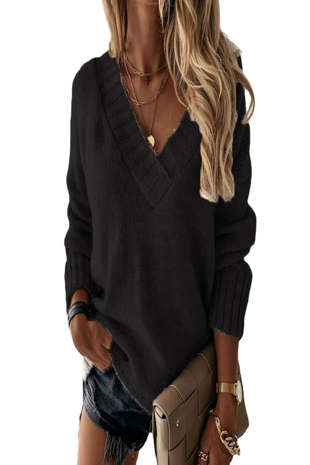 Woman wearing a black V-neck knit sweater with fitted black jeans